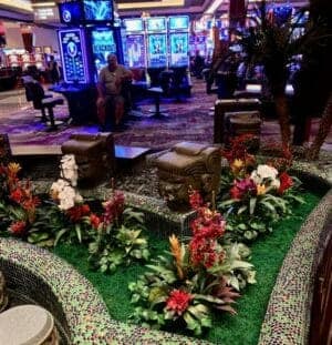 Elegant casino lounge with lush silk floral decor and vibrant lighting.