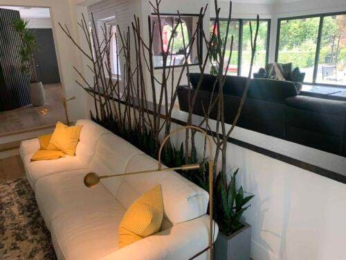 Stylish interior featuring a white sofa, yellow cushions, and decorative branches